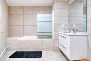 a bathroom with a tub and a sink at Luxueux appartement Paris proche Tour Eiffel Champs Elysées La Défense in Puteaux +31 photos