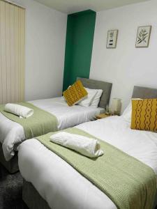 three beds in a room with green and white at Manchester Etihad Stadium Apartment by Daley Stays in Manchester