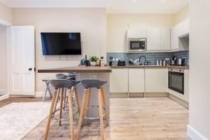 a kitchen with a counter and stools in it at St Andrews - 5 min walk to centre in St Andrews