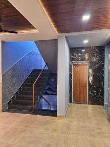 a staircase in a house with a stone wall at Hotel KT's Happy Stay Kolhapur 2 km from kolhapur airport in Kolhapur