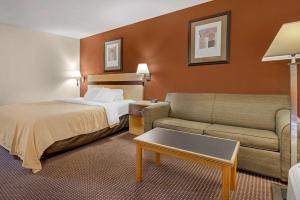 ObetzにあるQuality Inn & Suites Southのベッドとソファ付きのホテルルーム