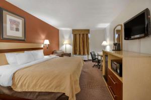 a hotel room with a bed and a flat screen tv at Quality Inn & Suites South in Obetz