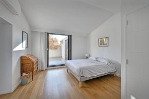 a white bedroom with a bed and a window at Le loft des Papes - Vue Panoramique sur la ville - AC CLIM - 2 terrasses - Hypercentre in Avignon