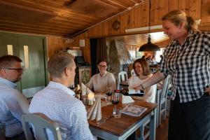 a man holding a bottle of wine at a table at Lifjellstua in Lifjell