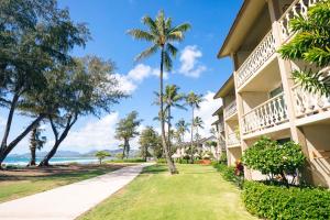 a building with palm trees next to the beach at Aston Islander On The Beach in Kapaa