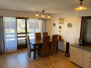uma mesa de jantar e cadeiras numa cozinha em La Foret 42 2 bedroom apartment with parking and sauna em Riddes