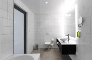 a white bathroom with a sink and a toilet at Fosshotel Reykjavík in Reykjavík