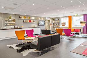 a waiting room with colorful chairs and a table at Sure Hotel by Best Western Stockholm Alvsjo in Stockholm