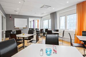 een vergaderzaal met tafels en stoelen en een whiteboard bij Sure Hotel by Best Western Stockholm Alvsjo in Stockholm