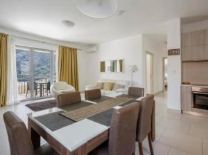 Un comedor con una mesa y una sala de estar. en Lavender Bay Apartment C21, en Donji Morinj