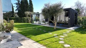 a garden with a glass house with a tree in it at Best Western Plus Sabaudia Hotel in Sabaudia