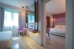 a bedroom with a bed and a desk with a tv at Best Western Plus Sabaudia Hotel in Sabaudia