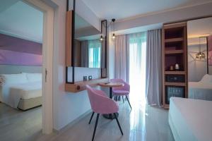 a bedroom with a bed and a table and two chairs at Best Western Plus Sabaudia Hotel in Sabaudia
