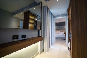 a room with a bedroom with a bed and a mirror at Best Western Plus Sabaudia Hotel in Sabaudia