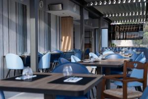 a restaurant with blue chairs and tables and tablesktop at Best Western Plus Sabaudia Hotel in Sabaudia