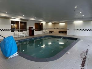 una gran piscina en una gran habitación con sillas y mesas en SureStay Plus by Best Western Fenton en Fenton