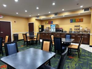 a restaurant with tables and chairs and a counter at SureStay Plus by Best Western Fenton in Fenton