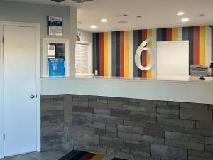 a lobby with a counter with a number on the wall at Motel 6 Greenville, NC ECU Medical Center in Greenville +17 photos