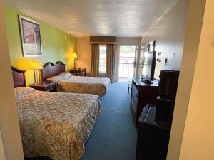 um quarto de hotel com duas camas e uma televisão em Motel 6 Bracey, VA I 85 em Bracey