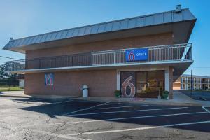 una tienda frente a un edificio con balcón en Studio 6 Suites Perry, GA, en Perry