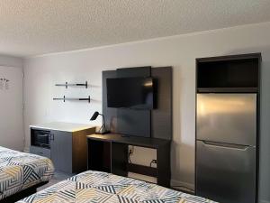 佩里Studio 6 Suites Perry, GA的酒店客房,设有床铺、电视和床铺。