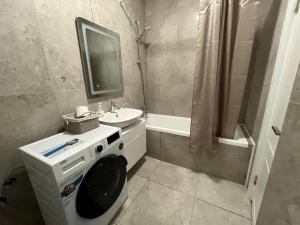 een badkamer met een wastafel, een toilet en een spiegel bij Трехкомнатная комфортная квартирка на Верхней Меге in Alma-Ata