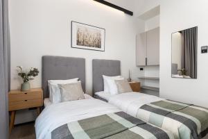 dos camas sentadas una al lado de la otra en un dormitorio en Väo Keskus Modern Guest Apartments, en Tallin
