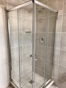 a shower with a glass door in a bathroom at Modern-eco apartment in Sandown