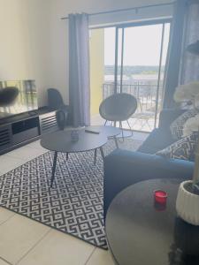Modern-eco apartment في Sandown: غرفة معيشة مع طاولتين وأريكة