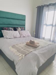 ein Bett mit einer Decke und einem Handtuch darauf in der Unterkunft Modern-eco apartment in Sandown