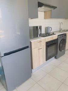 eine Küche mit einem Kühlschrank und einem Geschirrspüler in der Unterkunft Modern-eco apartment in Sandown