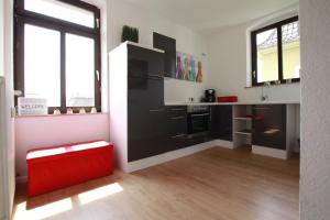 eine Küche mit einem schwarzen Kühlschrank und einem roten Stuhl in der Unterkunft Ferienwohnung 3 ANNA IFF in Würzburg