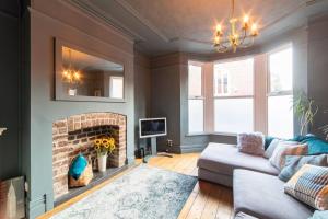 a living room with a couch and a fireplace at Orange Rentals-Free Parking - 4-Bed home near Sefton Park in Liverpool