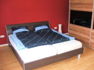 uma cama num quarto com uma parede vermelha em Lea´s Apartment´s em Dortmund
