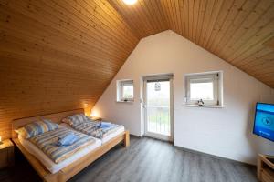 1 dormitorio con 1 cama y TV en una habitación en Ferienhaus Austernfischer, en Otterndorf