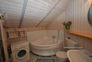 ein Badezimmer mit einer Badewanne, einem WC und einem Waschbecken in der Unterkunft Ferienhaus Korsör in Otterndorf