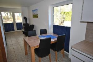 cocina y comedor con mesa de madera y sillas en Ferienhaus Seestern I, en Otterndorf