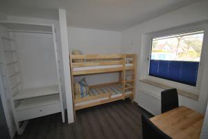 - une chambre avec des lits superposés et une fenêtre dans l'établissement Ferienhaus Seestern I, à Otterndorf