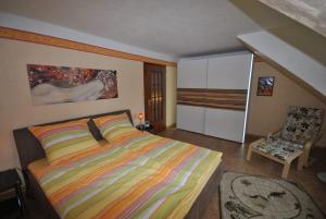 um quarto com uma cama king-size e uma cadeira em Ferienhaus Medemsonne em Otterndorf