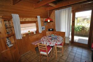a dining room with a table and chairs in a cabin at Ferienhaus Sturmtaucher in Otterndorf +4 photos