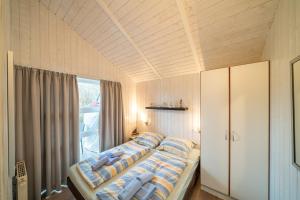 een slaapkamer met een bed met kussens en een raam bij Ferienhaus Wyk auf Föhr in Otterndorf