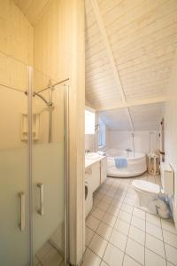 een badkamer met een bad, een toilet en een wastafel bij Ferienhaus Wyk auf Föhr in Otterndorf
