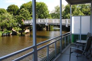 een brug over een rivier met tafels en stoelen bij Ferienwohnung Korte in Otterndorf