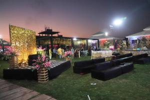 un gruppo di divani neri sull'erba di notte di Ananda Resort a Pushkar