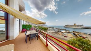 d'un balcon avec une table et des chaises et une vue sur le port. dans l'établissement Rooftop Marina l by Madeira Best Apartments, à Funchal