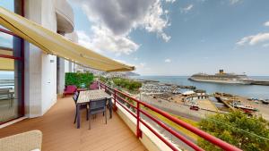 a balcony with a table and chairs and a view of a harbor at Rooftop Marina l by Madeira Best Apartments in Funchal