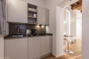 a kitchen with white cabinets and a sink at Trevi Steps in Rome