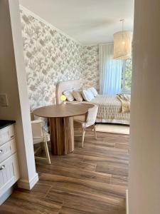 a living room with a table and a bed at El Salto Suites - Casonas del Haras in Mar del Plata