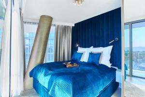 a blue bedroom with a large blue bed with white pillows at Your Holidays Waves Złote Filary D653 in Międzyzdroje +31 photos