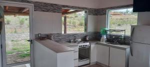 a kitchen with a refrigerator and a stove top oven at Los Cactus in Tafí del Valle